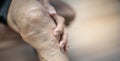 Close up of old man hand holding on the knee with suffering from knee pain. The sick legs of an old man with severely deformed Royalty Free Stock Photo