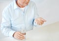 Close up of old man with pills and water glass