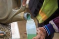 Close up an old man pouring gasoline from a gallon to a measuring bottle before refueling the engine