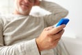 Close up of old man texting on smartphone at home Royalty Free Stock Photo