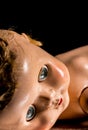 Close up of old neglected doll against a black background. Royalty Free Stock Photo