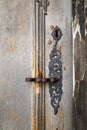 Ornate metal lock with a handle and keyhole on a light brown wooden door Royalty Free Stock Photo