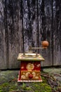 Old painted coffee grinder outsdie in front of weathered wooden door Royalty Free Stock Photo