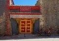 CLOSE UP: Old red motorbike is parked by the entrance to an incense factory. Royalty Free Stock Photo