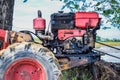 Close up of the old red tiller tractor or walking tractor parked under the tree in the fields at countryside, Thailand Royalty Free Stock Photo