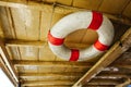 Close up old red and white life buoy hanging on wooden ceiling of passenger boat, copy space Royalty Free Stock Photo