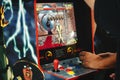 Close-up of an old retro gaming arcade game - Mortal Kombat II, with a man\'s hands on the control panel