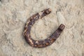 Close-up of an old rusty horseshoe propped on a big stone. Royalty Free Stock Photo