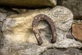 Close-up of an old rusty horseshoe propped on a big stone. Royalty Free Stock Photo