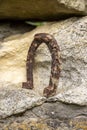 Close-up of an old rusty horseshoe propped on a big stone. Royalty Free Stock Photo