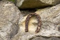 Close-up of an old rusty horseshoe propped on a big stone. Royalty Free Stock Photo