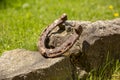Close-up of an old rusty horseshoe propped on a big stone. Royalty Free Stock Photo