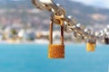 Close up of old rusty locks on chain against background of city and sea. Blurred backgroud Royalty Free Stock Photo