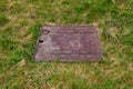 Close up of a old rusty metal square hatch in a grass field Royalty Free Stock Photo