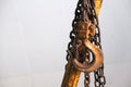 Close up old rusty yellow crane hook with chain, warehouse or cargo storage equipment Royalty Free Stock Photo