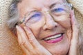 Close up of old senior woman smiling and holding her face with hands. Happiness and youthness concept lifestyle with old female Royalty Free Stock Photo