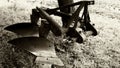 old shiny steel plough in closeup view in sepia under tree with freshly turned soil background Royalty Free Stock Photo