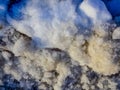 Close up of old snow texture with colors transfering from white to light brown, blue, and gray. Full frame. Background