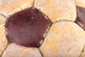 Close-up of an old soccer ball on the leg on a white table. Leather and destroyed ball without air Royalty Free Stock Photo