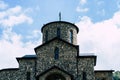 Close up of old stone church on background of blue sky with white clouds. Architecture of monastery from uneven