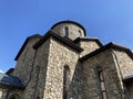 Close up of old stone church on background of blue sky with white clouds. Architecture of monastery from uneven