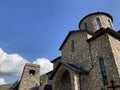 Close up of old stone church on background of blue sky with white clouds. Architecture of monastery from uneven