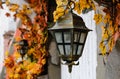 close-up, old street lamp against the background of a wall and autumn foliage Royalty Free Stock Photo