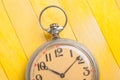 Close up of old style pocket watch on yellow wooden backround Royalty Free Stock Photo