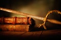 Old sword with leather books on wooden table Royalty Free Stock Photo