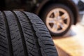 Close up of old tire with car wheel background. Tire workshop and change old wheel on the car. Used car tires stacked in piles at Royalty Free Stock Photo