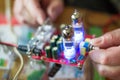 Close up old tube amplifier in male hands. Process of testing music detail with voltmeter. Illuminated lamps sound plate Royalty Free Stock Photo