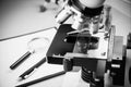 Close up of old vintage of microscope with metal lens, science equipment, pen, pencil and magnifying glass at at laboratory. Royalty Free Stock Photo