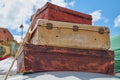 Close-up of old vintage travel suitcases fastened to the roof of a car with a rope and in the background a lovely blue sky with cl Royalty Free Stock Photo