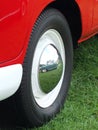 Close up of an old vw combi van wheel with a vintage green mini reflected in the chrome hubcap at the Hebden Bridge Vintage Weeken Royalty Free Stock Photo