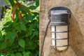 Close up old wall lamp on concrete wall with green natural in the background. Royalty Free Stock Photo