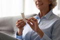 Close up of old woman read prescription on meds bottle