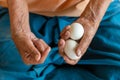 Close-up of the old woman's hand Poor Thai grandmother holds a large white duck egg for dinner. Royalty Free Stock Photo