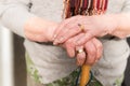 Close up of old woman`s hands on umbrella handle.