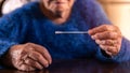 Close-up of old woman taking a self swabbing home tests Covid19 with antigen kit Royalty Free Stock Photo