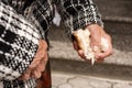 close-up of the old woman& x27;s hands, a piece of broken bread in the woman& x27;s hands. Poverty and starving pensioners
