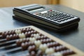 Close-up old wooden abacus and a calculator on a black table Royalty Free Stock Photo