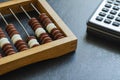 Close-up old wooden abacus and a calculator on a black table Royalty Free Stock Photo