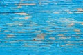 Close up of a old wooden door, teal blue paint peeling off; text