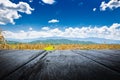 Old wooden floor beside the agricultural field and mountain with blue sky Royalty Free Stock Photo