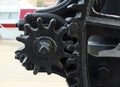 Close up of old worn black painted large cog wheels with gear teeth on obsolete industrial machinery