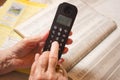 Close up of old wrinkled hands dialing a phone number from address book. Royalty Free Stock Photo