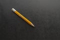 Close-up of an old yellow wooden pencil on black table Royalty Free Stock Photo