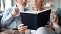 Close up older couple reading book together at home Royalty Free Stock Photo