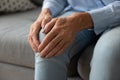 Close up older woman touching knee with hands, feeling pain