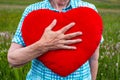 Close-up of an older womans hand holding red fluffy heart